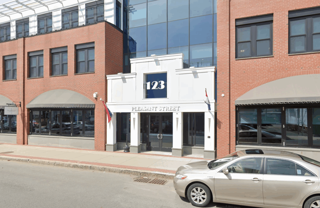 Entrance of 123 Pleasant Street office building, brick facade, parked car in front