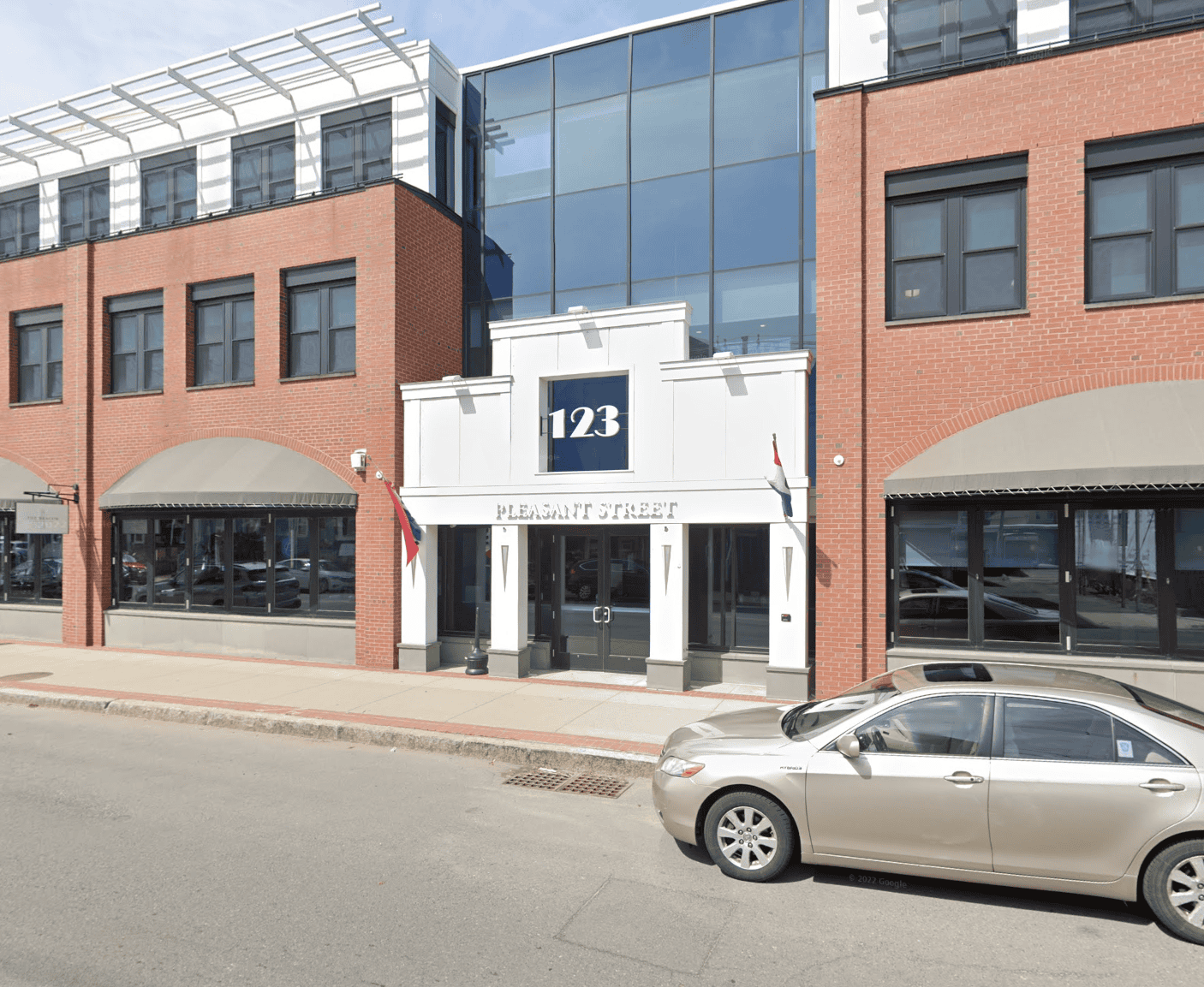 Entrance of 123 Pleasant Street office building, brick facade, parked car in front